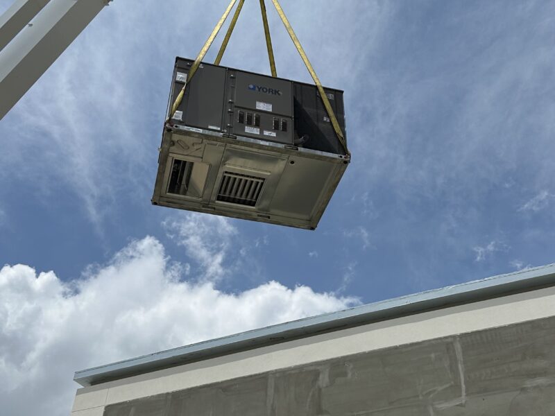 Commercial York rooftop unit being craned onto roof